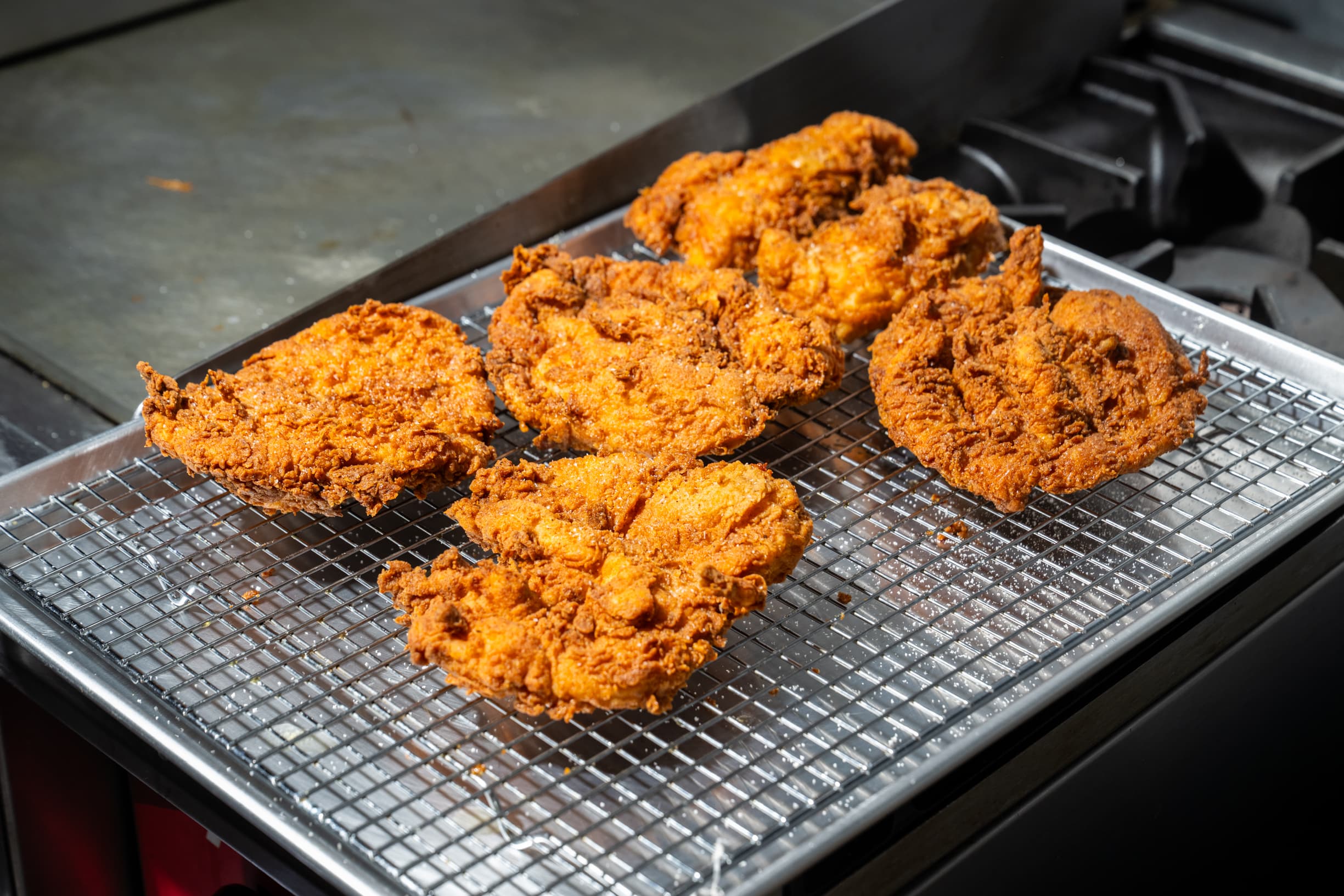 Golden fried chicken breast resting on a tray