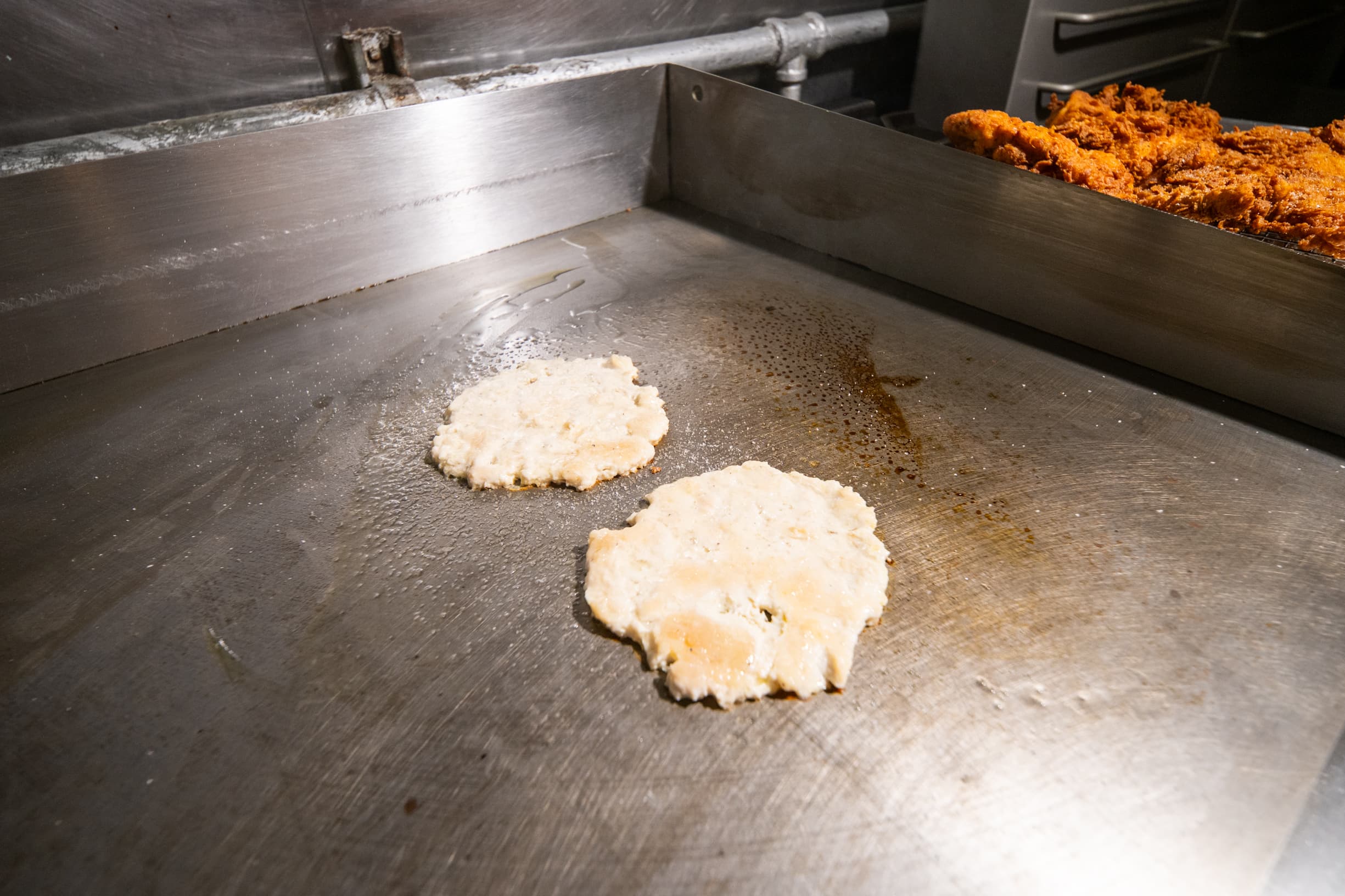 Raw chicken just placed on a grill before frying