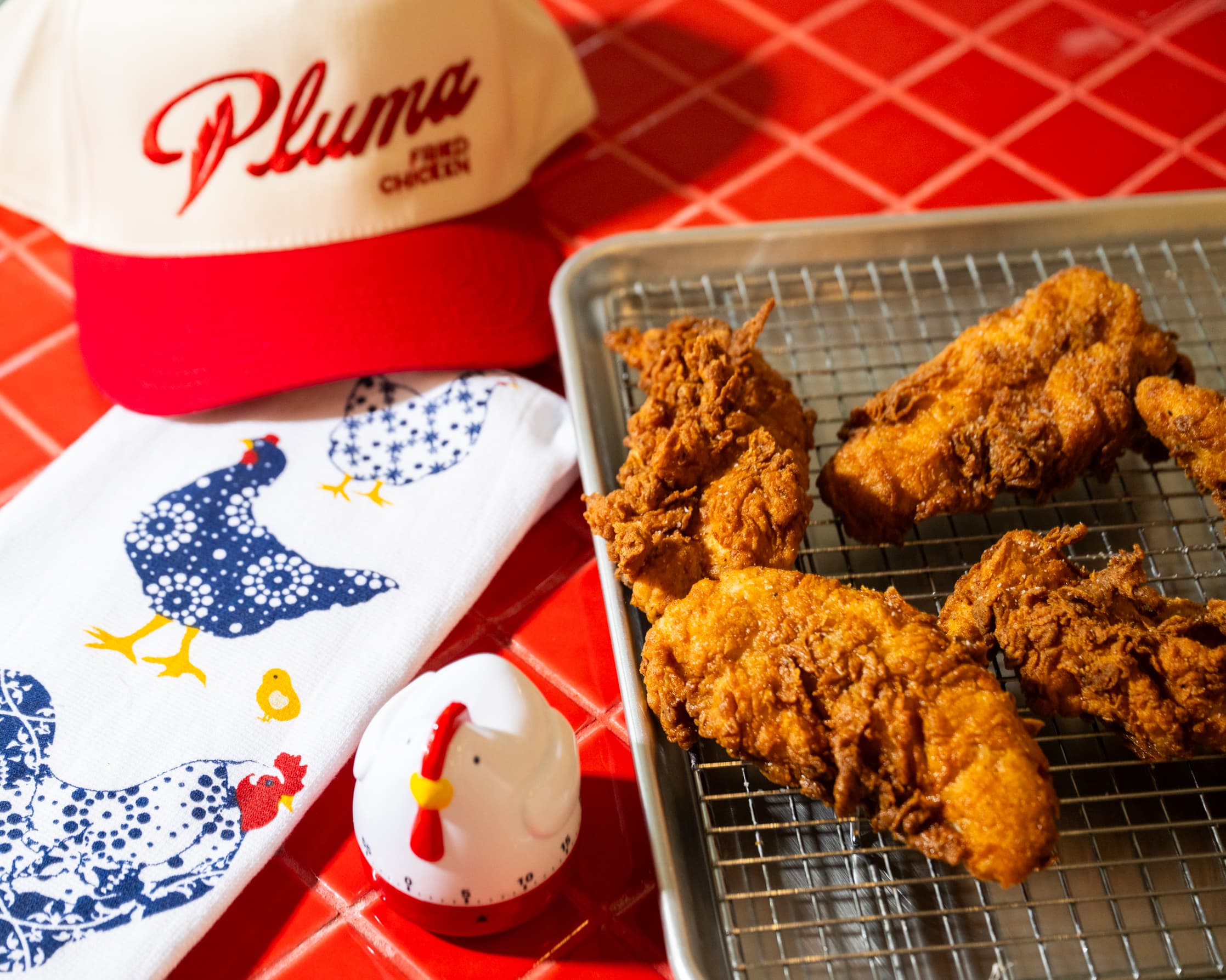 Fried chicken piece next to Pluma branded packaging