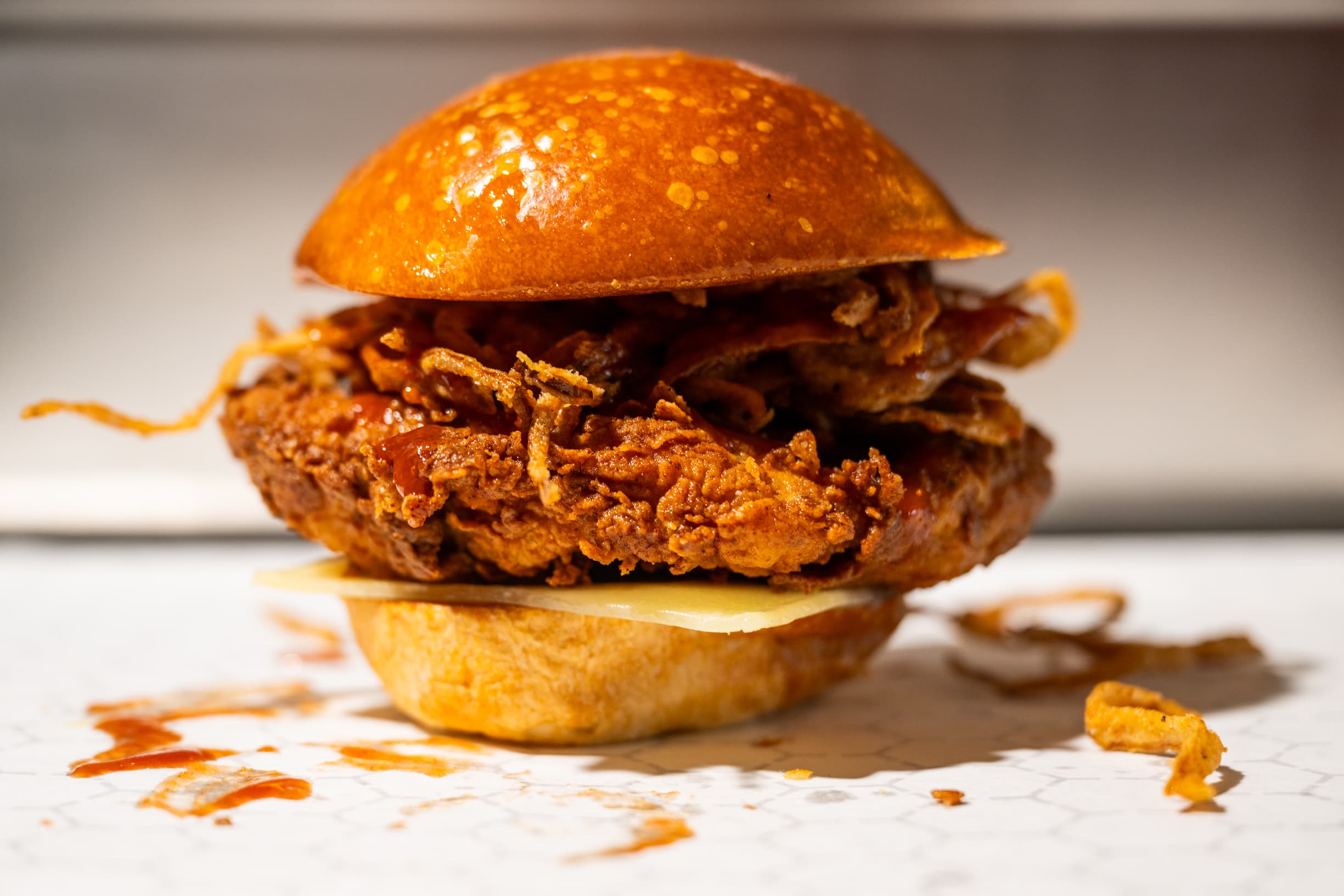 Close-up of Pluma BBQ sandwich showing the sauced chicken patty
