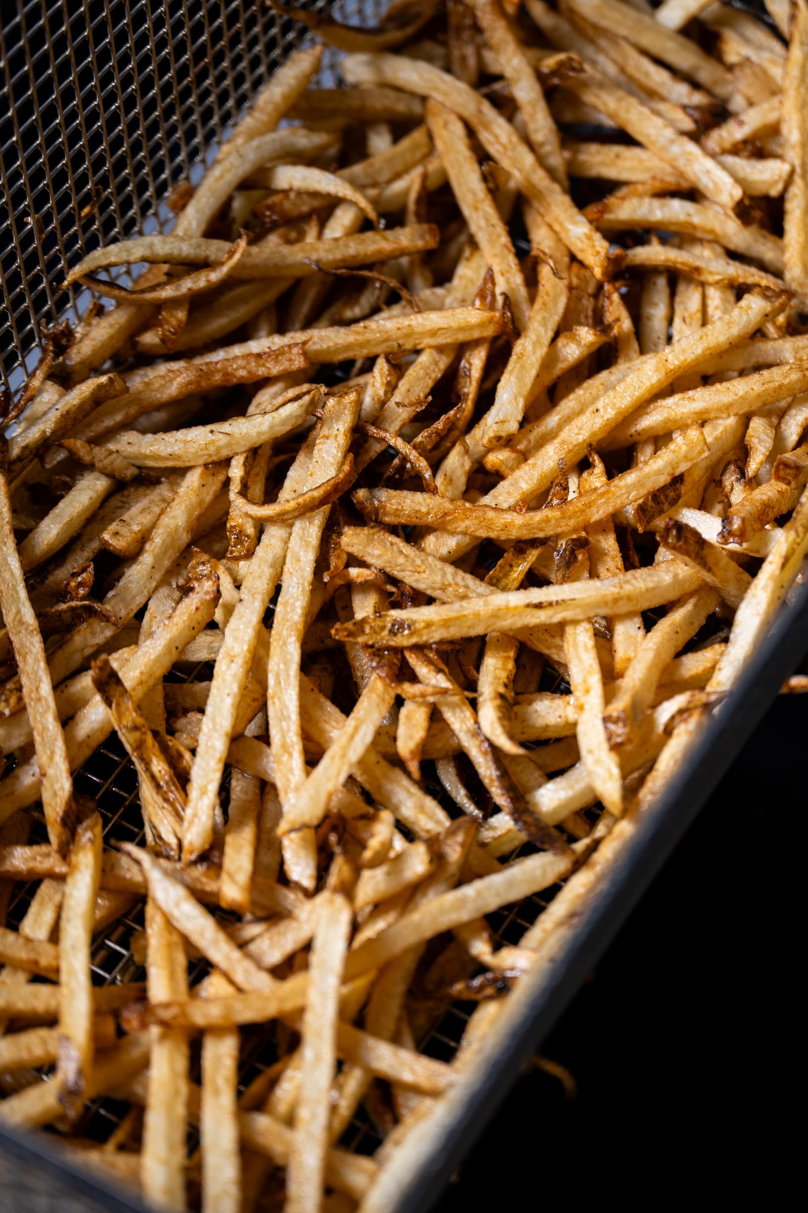 Beef tallow fries piled in a wire basket